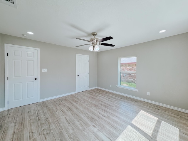 spare room featuring visible vents, baseboards, and light wood-style flooring