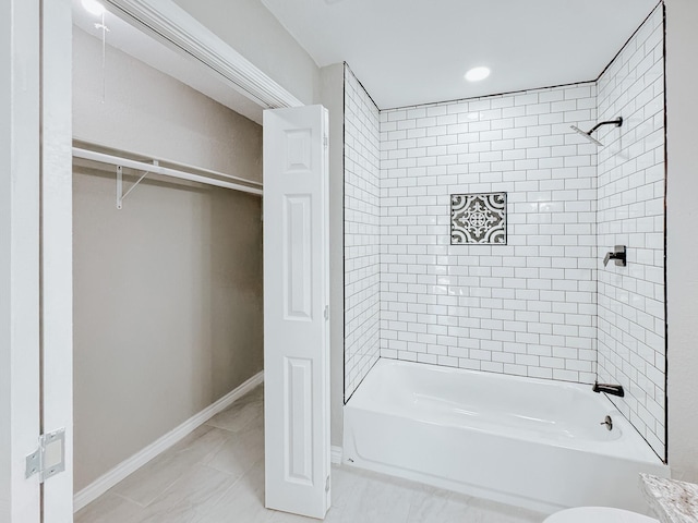 full bath featuring bathtub / shower combination, a walk in closet, and baseboards