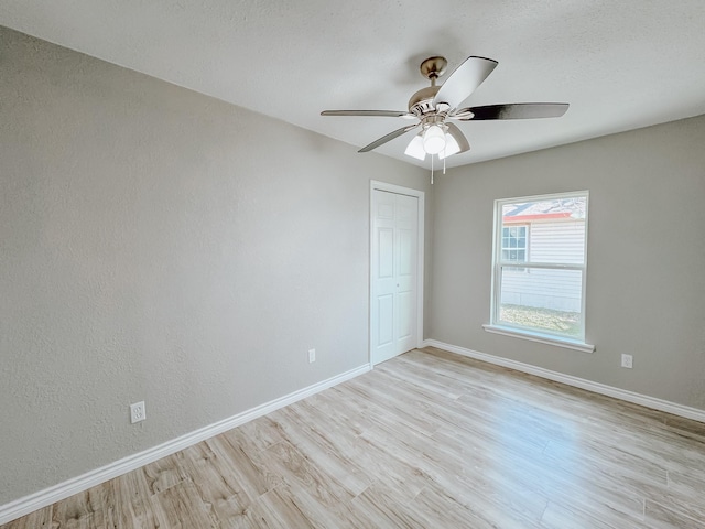 unfurnished room with light wood-style flooring, baseboards, and ceiling fan