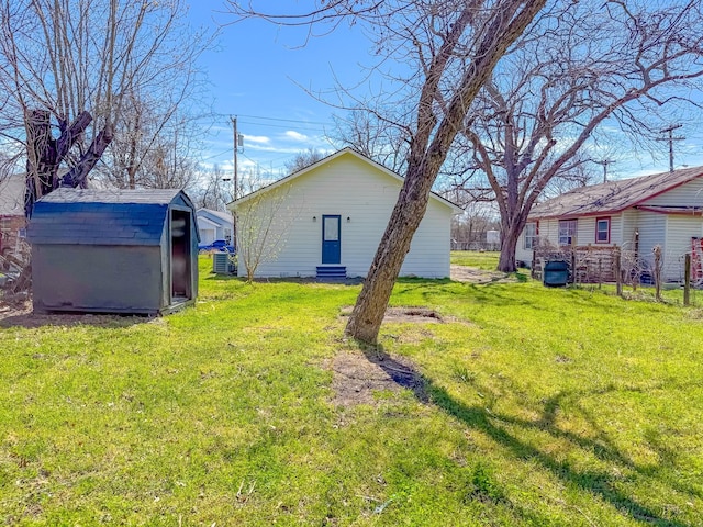 view of yard featuring entry steps, an outbuilding, and a shed