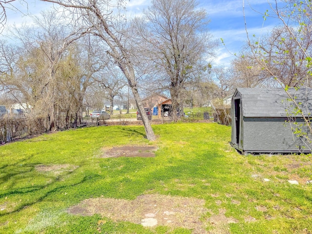 view of yard featuring a storage shed, an outbuilding, and fence