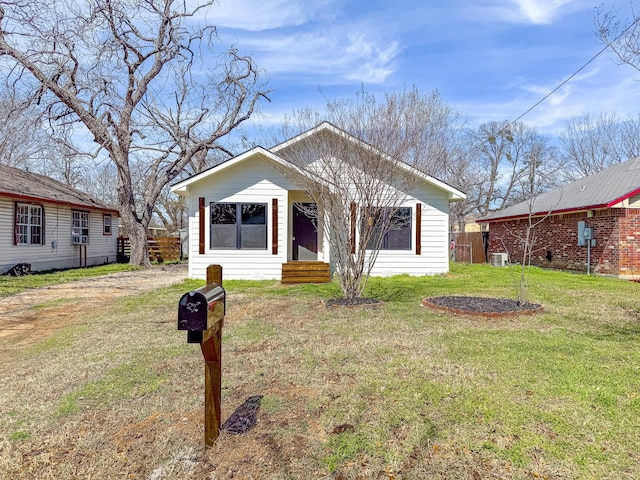 view of front of house featuring cooling unit, a front yard, and dirt driveway