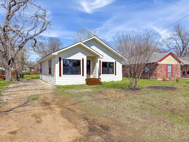 view of front of property featuring driveway and a front lawn