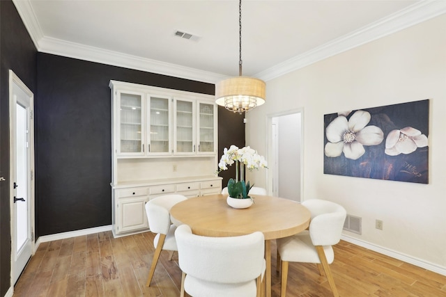 dining room featuring visible vents, baseboards, and light wood-style flooring