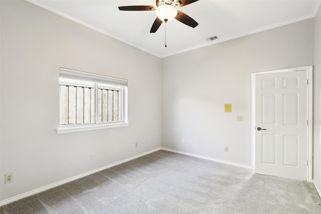 carpeted empty room featuring ceiling fan, baseboards, visible vents, and ornamental molding