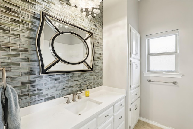 bathroom with vanity, baseboards, and tasteful backsplash