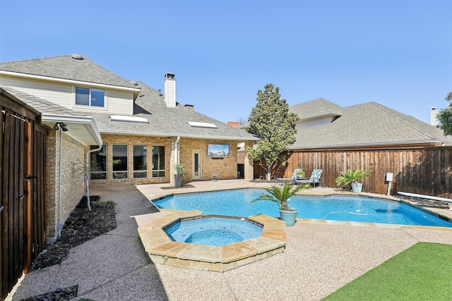 view of swimming pool with a fenced in pool, an in ground hot tub, a fenced backyard, and a patio area