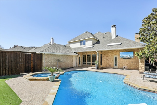 view of pool with fence, a pool with connected hot tub, and a patio area