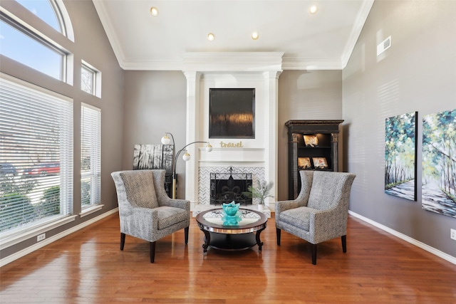 sitting room featuring visible vents, crown molding, baseboards, a fireplace, and wood finished floors