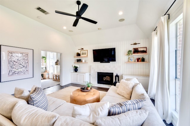 living area featuring visible vents, wood finished floors, recessed lighting, a fireplace, and vaulted ceiling