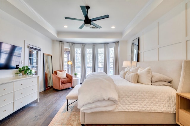 bedroom with visible vents, crown molding, a tray ceiling, recessed lighting, and dark wood-style flooring