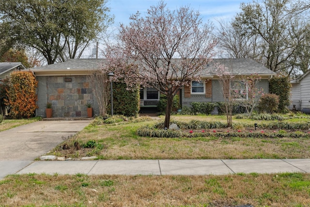 ranch-style home featuring stone siding and a front lawn