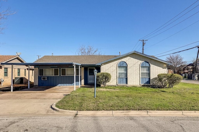 view of front facade featuring a front yard, brick siding, driveway, and roof with shingles