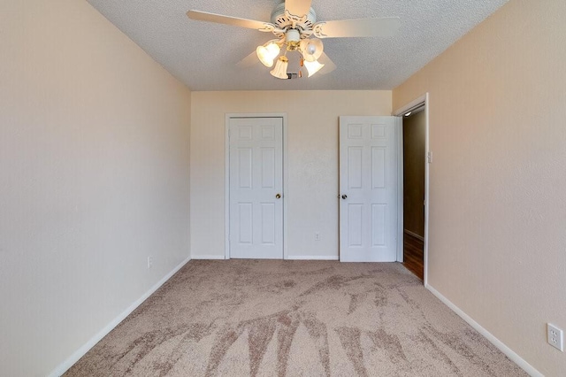 unfurnished bedroom with baseboards, a textured ceiling, ceiling fan, and carpet