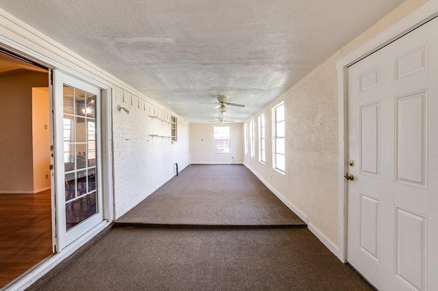 unfurnished sunroom with a ceiling fan