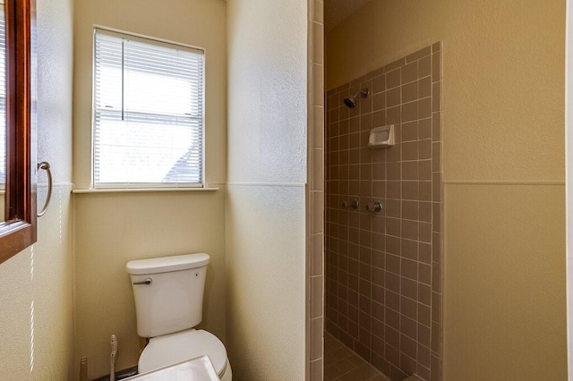 bathroom with toilet and tiled shower