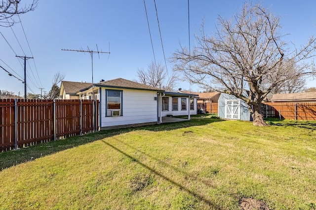 rear view of house with an outbuilding, a storage shed, a fenced backyard, and a lawn