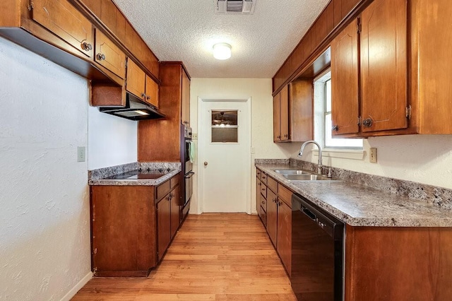 kitchen with visible vents, black appliances, light wood-style flooring, a textured ceiling, and a sink