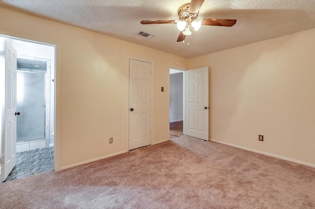 unfurnished bedroom featuring visible vents, baseboards, a textured ceiling, and carpet flooring