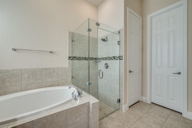 full bath featuring a garden tub, a stall shower, and tile patterned flooring