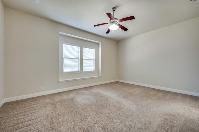 carpeted empty room featuring visible vents, baseboards, and ceiling fan