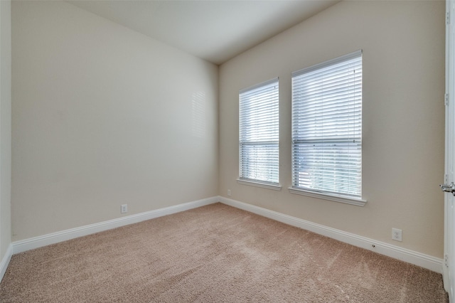 carpeted spare room featuring baseboards