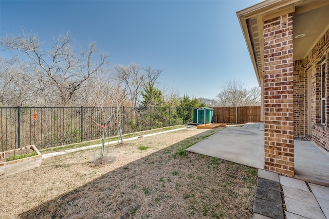 view of yard featuring a fenced backyard, a storage shed, an outdoor structure, and a patio area