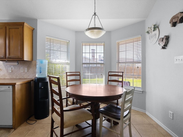 dining space featuring light tile patterned flooring, plenty of natural light, and baseboards