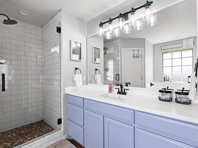 bathroom with a shower stall and vanity