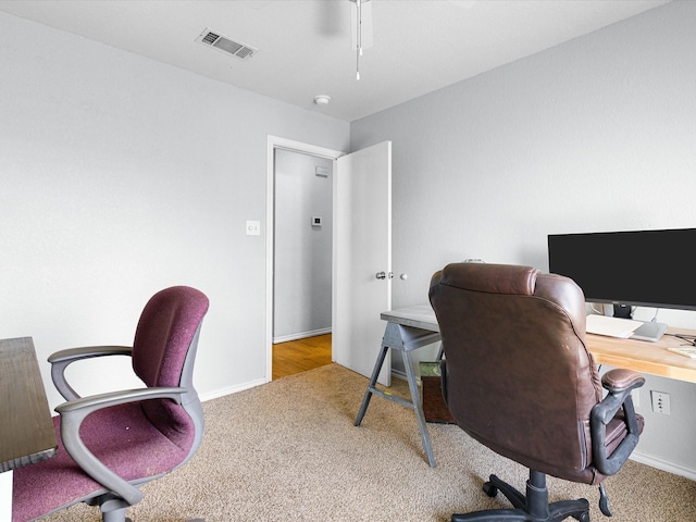 carpeted office with visible vents and baseboards