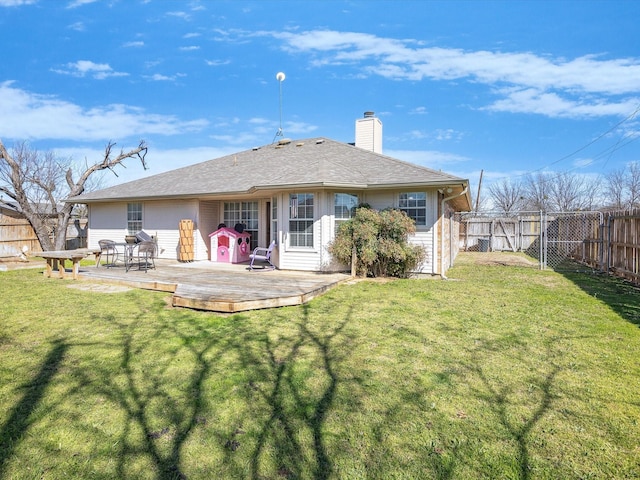 back of house with a wooden deck, a fenced backyard, a lawn, and a chimney