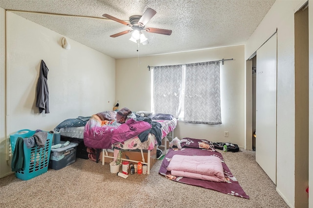 carpeted bedroom with a textured ceiling and ceiling fan