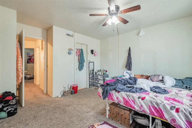 bedroom featuring a ceiling fan, visible vents, carpet floors, and a textured ceiling