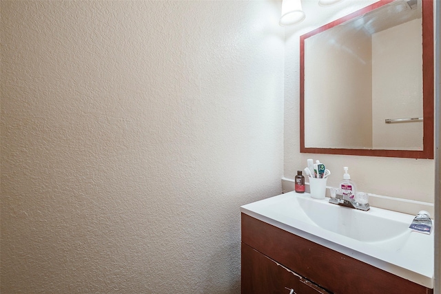 bathroom with vanity and a textured wall