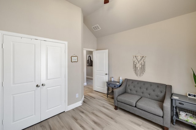 interior space with vaulted ceiling, baseboards, visible vents, and light wood finished floors