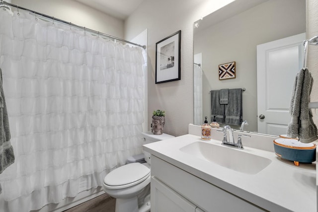 bathroom featuring curtained shower, toilet, and vanity