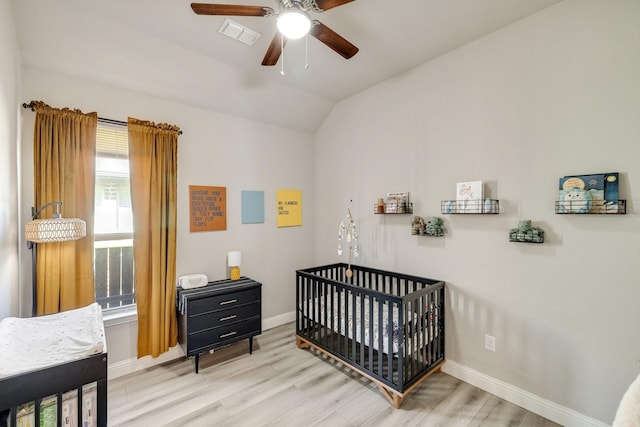 bedroom featuring visible vents, baseboards, light wood-type flooring, and lofted ceiling