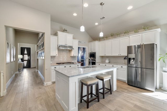 kitchen featuring visible vents, a sink, white cabinets, under cabinet range hood, and appliances with stainless steel finishes