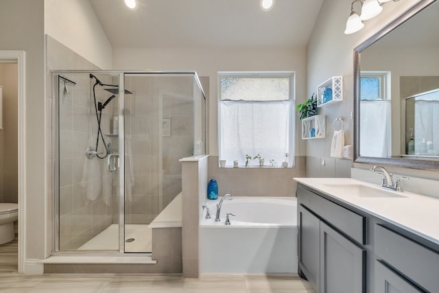 full bath featuring toilet, a stall shower, vanity, and a bath