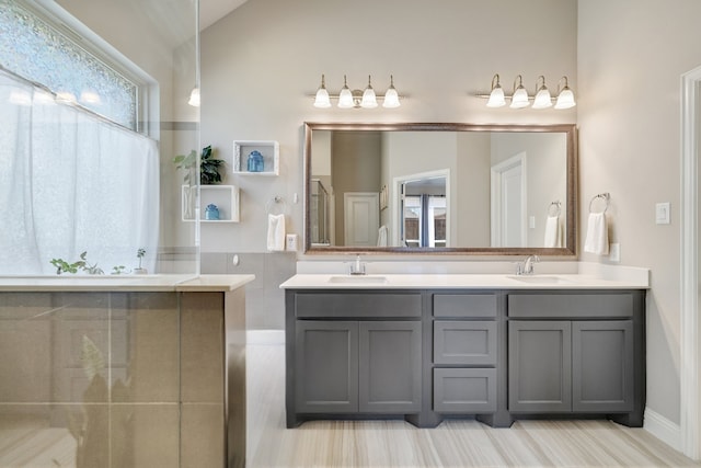 bathroom featuring double vanity, lofted ceiling, and a sink