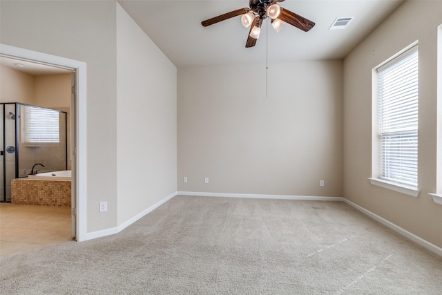 spare room featuring visible vents, carpet floors, baseboards, and ceiling fan