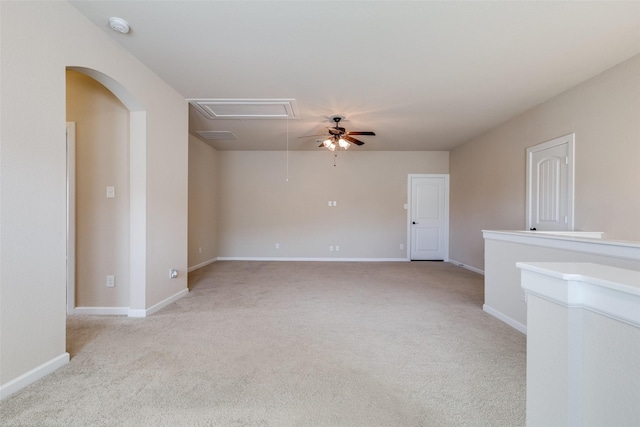 empty room featuring baseboards, light carpet, attic access, and ceiling fan