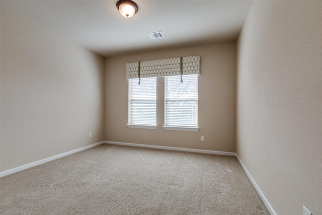 empty room with carpet flooring, baseboards, and visible vents