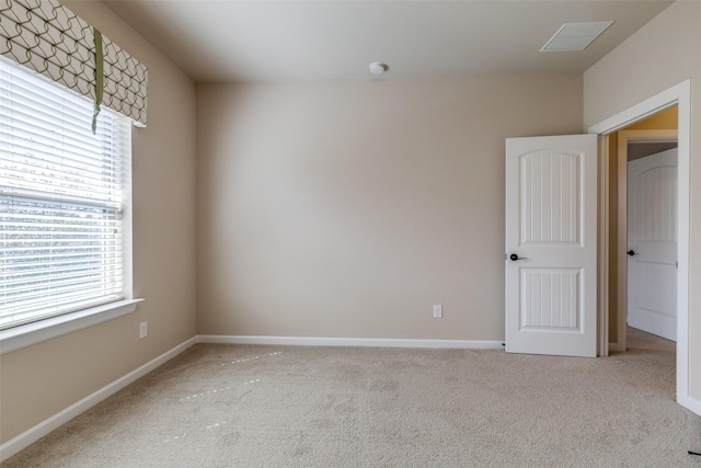 carpeted empty room featuring baseboards and visible vents