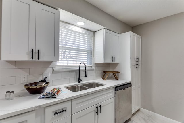 kitchen featuring tasteful backsplash, baseboards, dishwasher, marble finish floor, and a sink