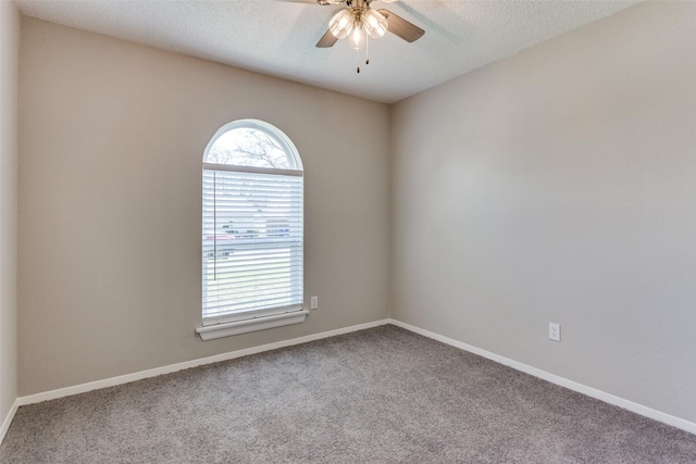 unfurnished room with a ceiling fan, baseboards, carpet floors, and a textured ceiling