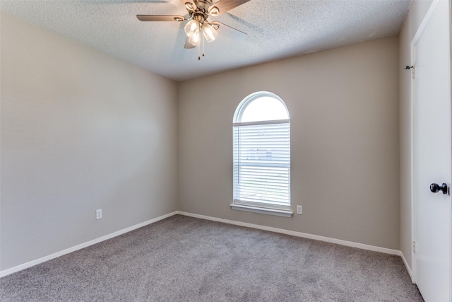 unfurnished room with a textured ceiling, carpet flooring, baseboards, and ceiling fan