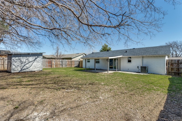 rear view of property with a lawn, a patio, a fenced backyard, an outdoor structure, and brick siding