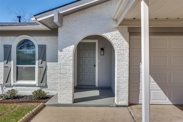 property entrance featuring stucco siding and an attached garage