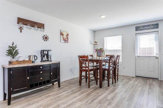 dining room with baseboards and light wood finished floors